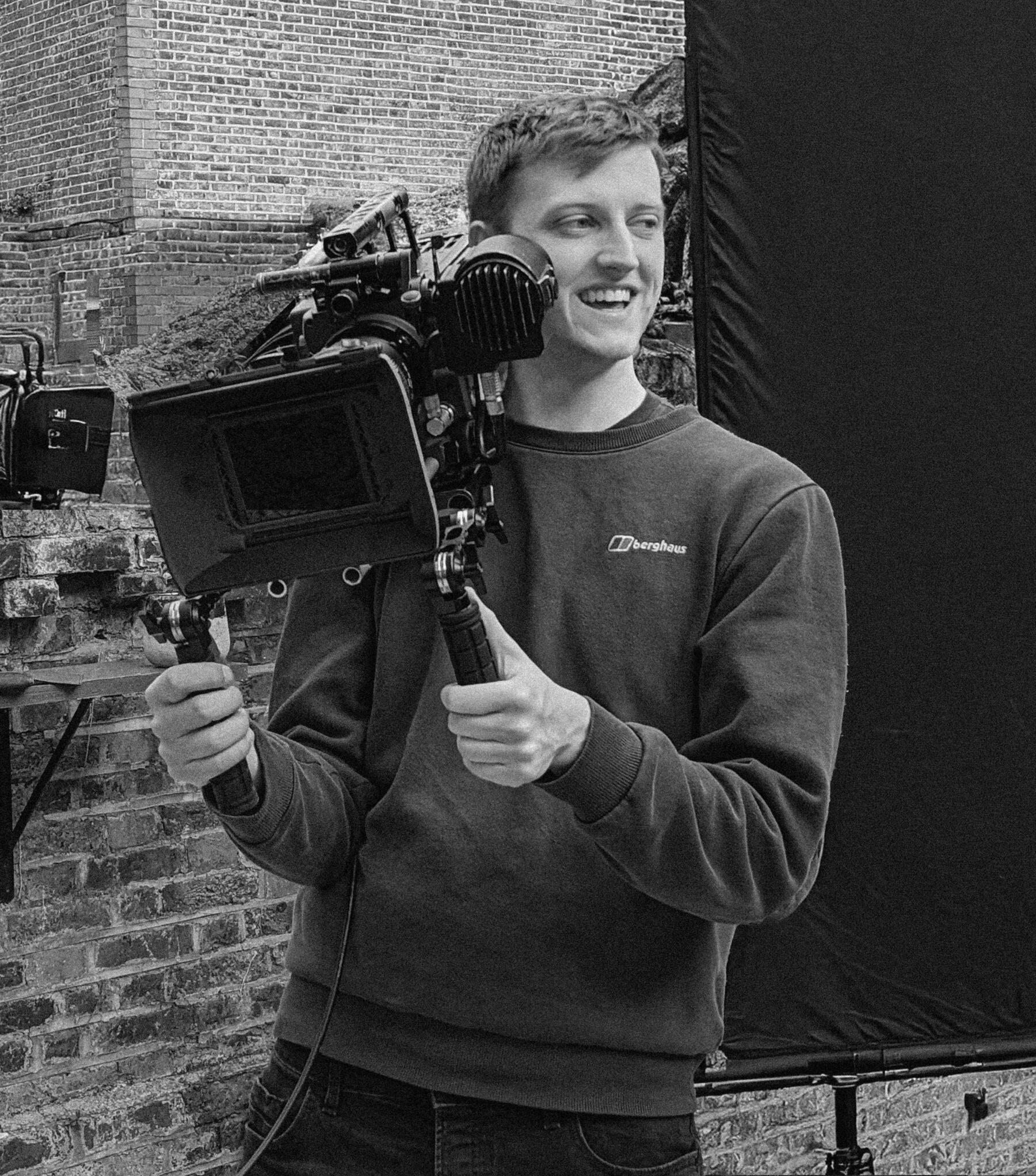 Ben holding a camera on his shoulder